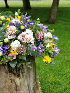 coffin spray filled with iris, roses, freesia